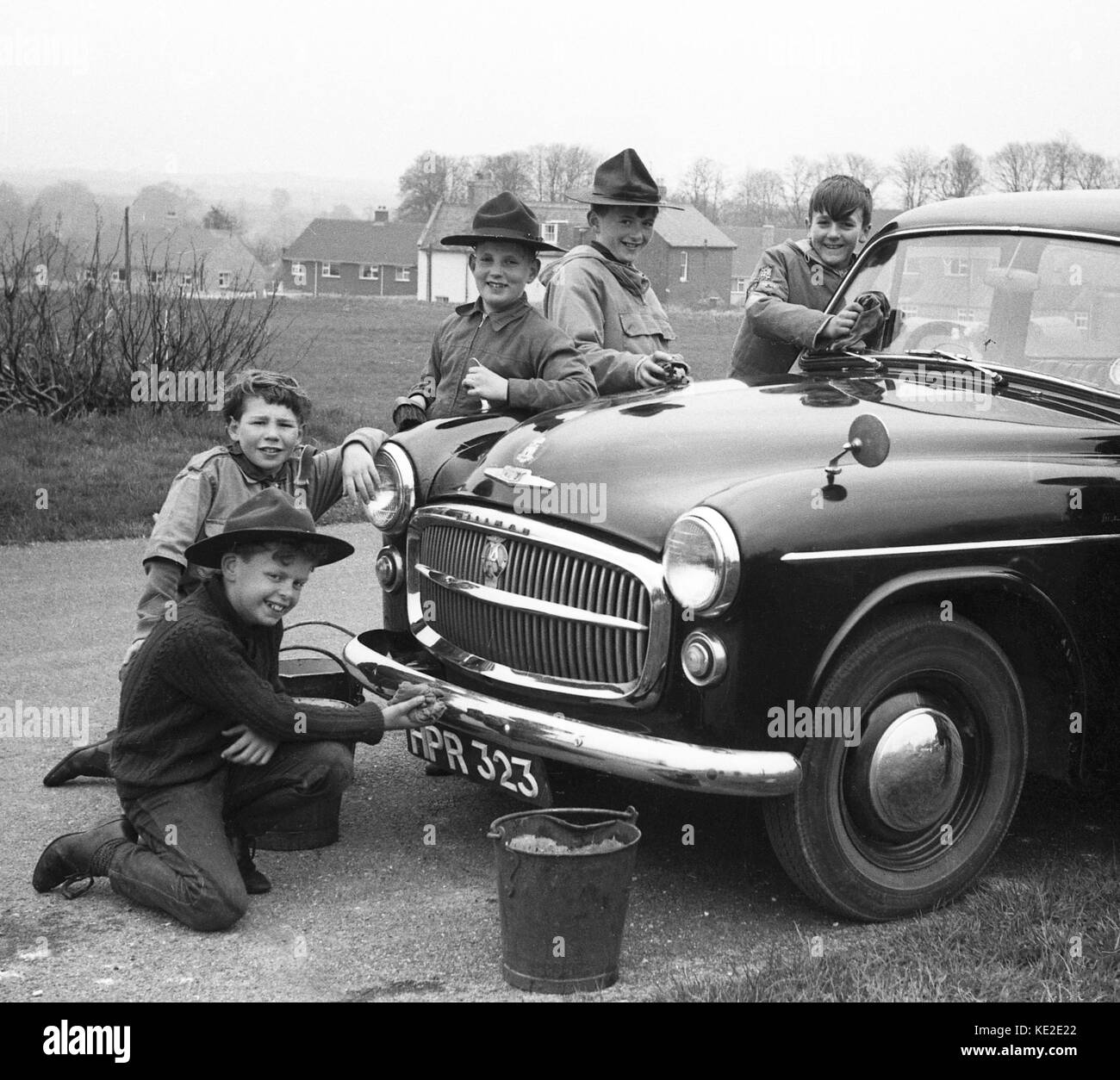 Boy scouts cleaning a Hillman car for bob-a-job week in 1966. boy scouts scouting scout 1960s Britain Uk Stock Photo