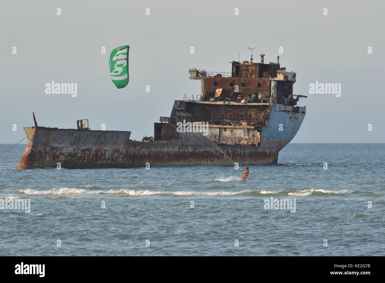 Female Kitesurfer in the sea with shipwreck in background in front of Kunduchi Beach Hotel north of Dar es Salem Tanzania Stock Photo