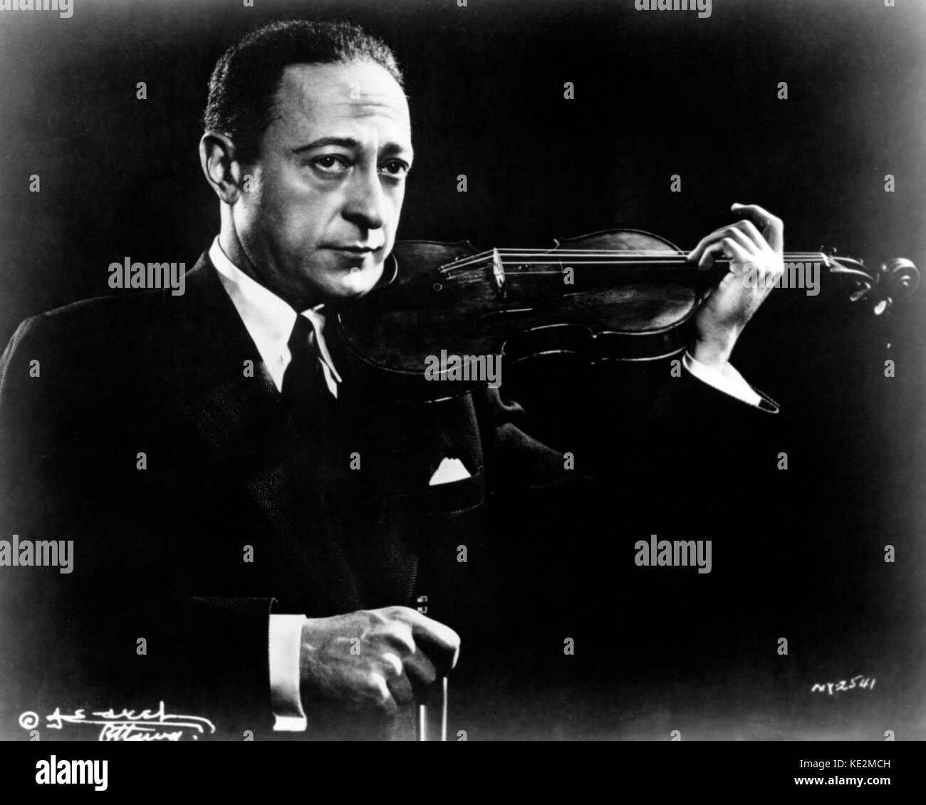 Jascha Heifetz holding a violin in playing position. Russian American