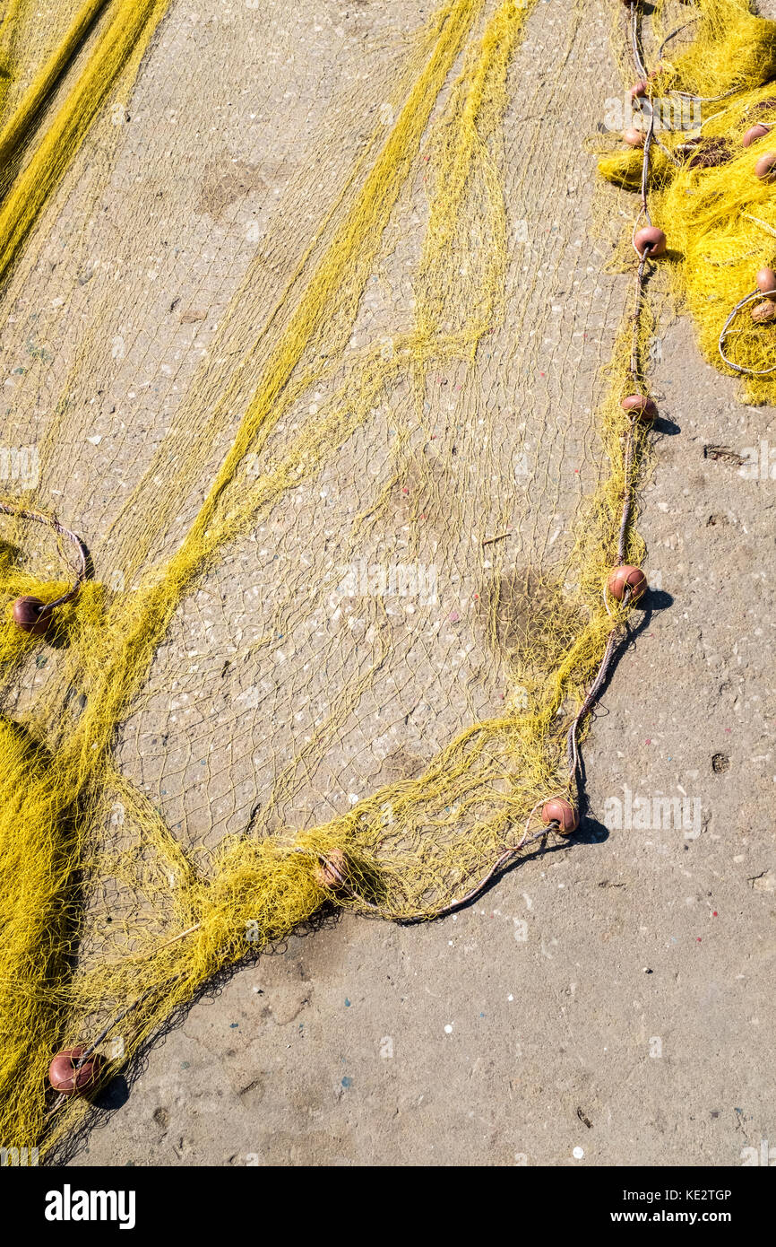 Fishing-net drying on harbour pavement Stock Photo