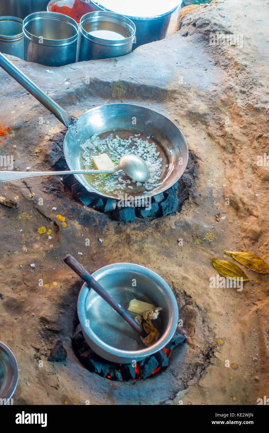Close up of Indian food inside of a metallic trays in the ground, using