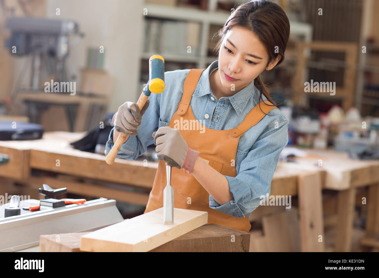 Portrait of young female woodworker concentrating on her work Stock