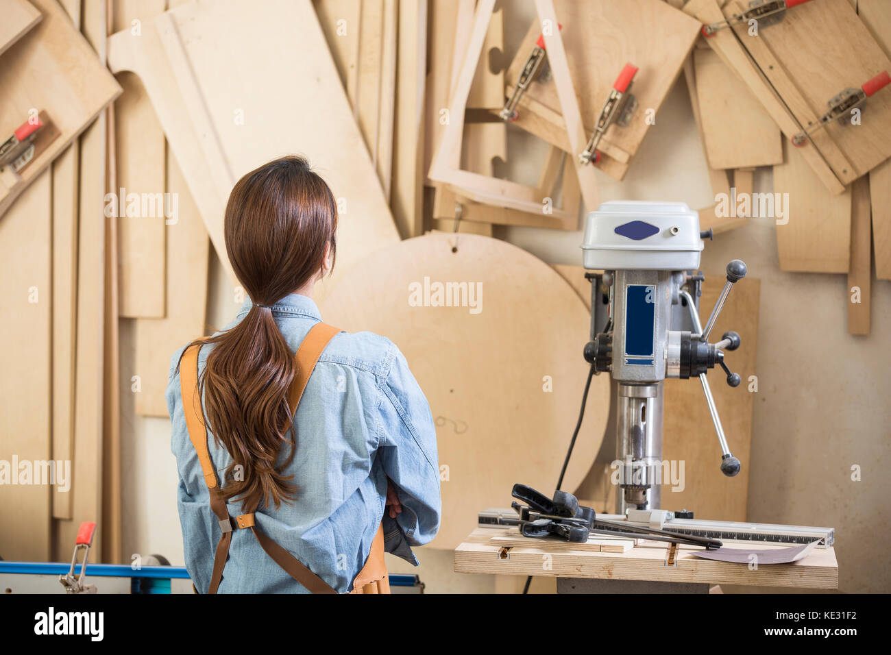 Back portrait of young female woodworker at carpenter's shop Stock Photo