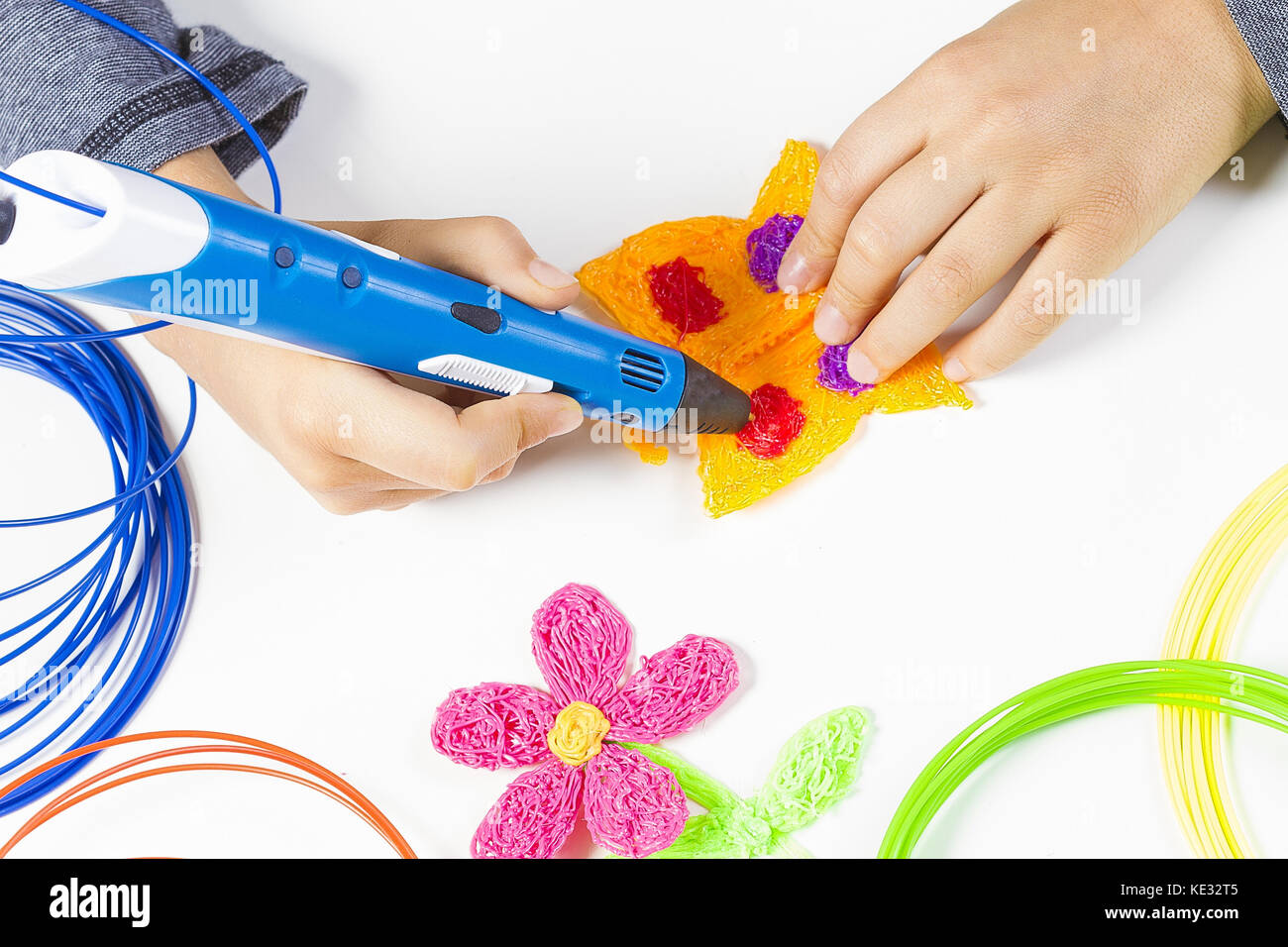 Kid hand holding blue 3d printing pen and making new item Stock Photo ...