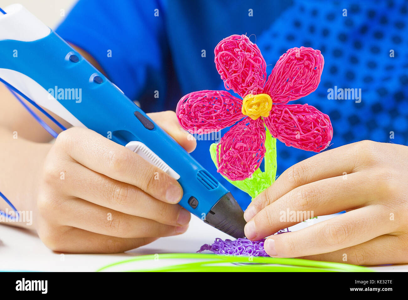 Kid hands holding blue 3d printing pen and making new item Stock Photo ...