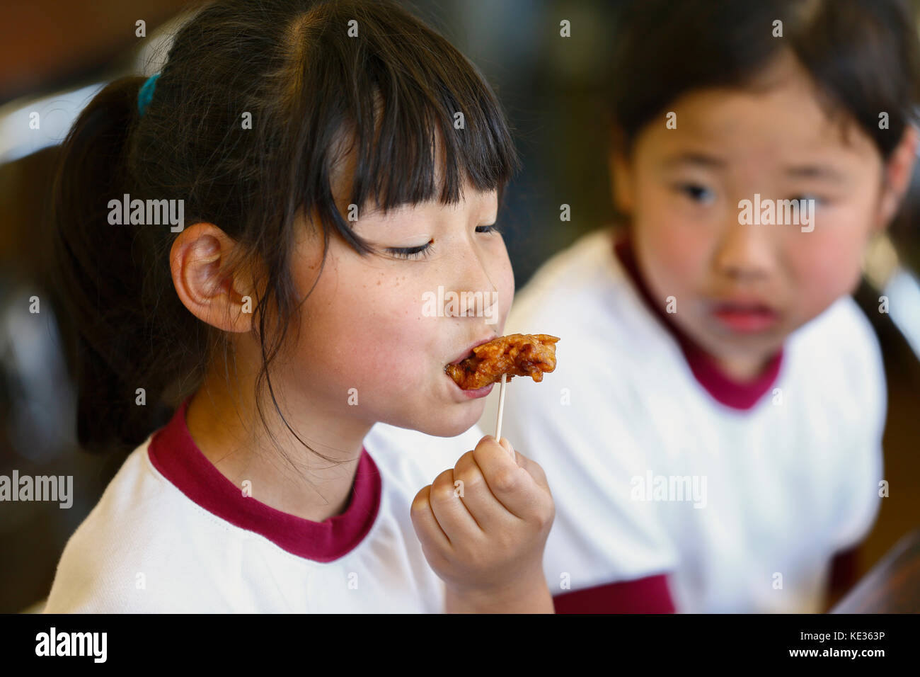 Japanese elementary school kids eating in the classroom Stock Photo