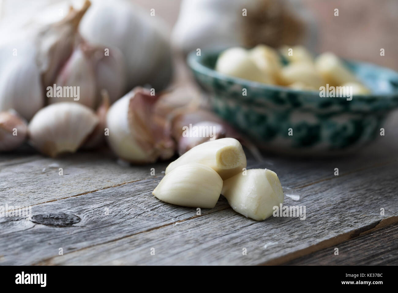 Close up of peeled garlic cloves with garlic head and unpeeled cloves