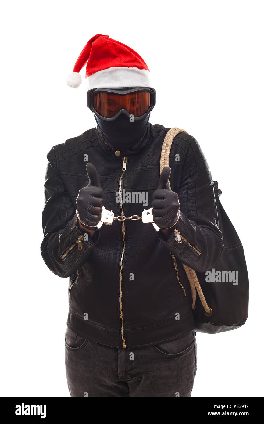 Arrested thief wearing mask and santa claus cap with handcuffs on