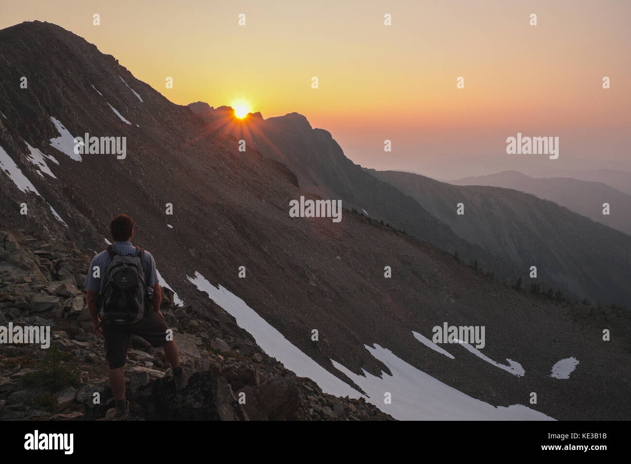 Hiker watching the sunset near the summit of Frosty Mountain in Manning provincial park, British Columbia, Canada. Stock Photo