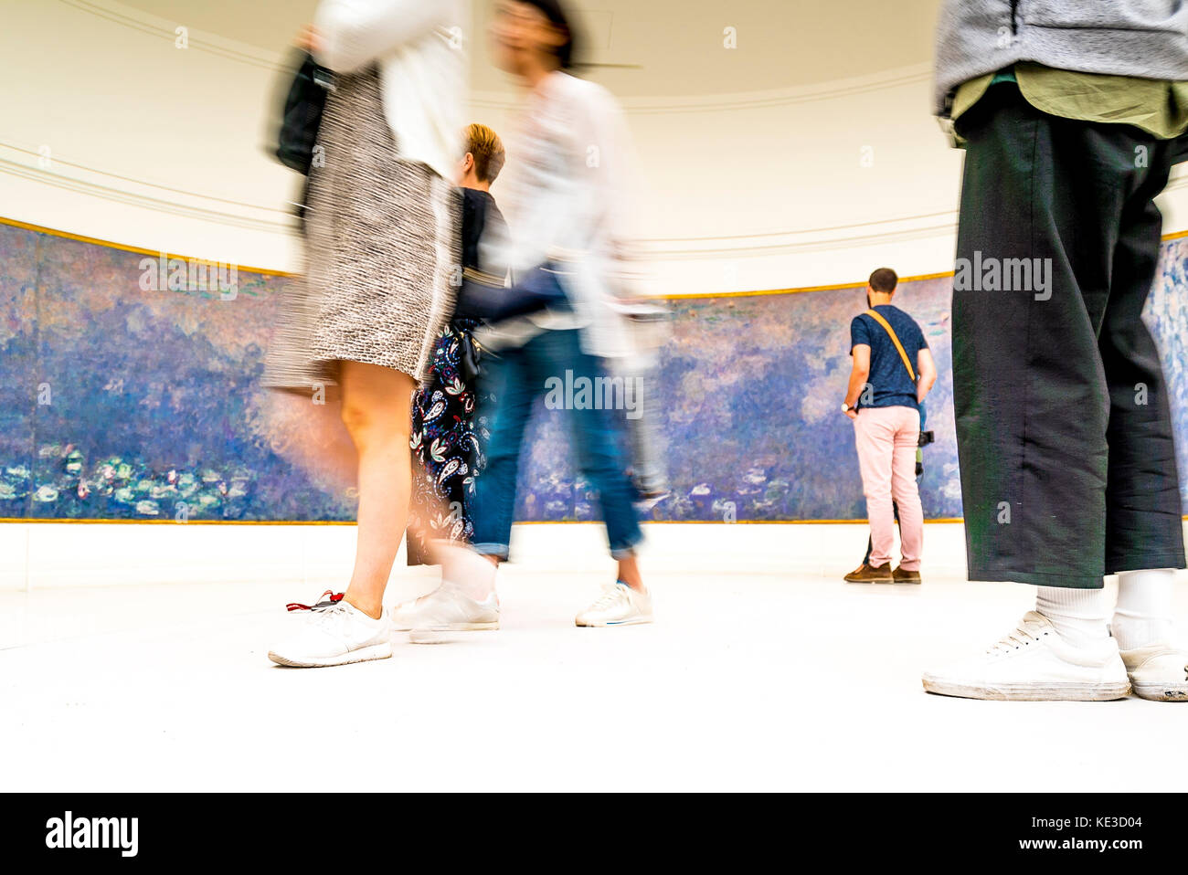 Visitors enjoy Claude Monet's large scale waterlilies paintings in the Orangerie Museum in Paris Stock Photo