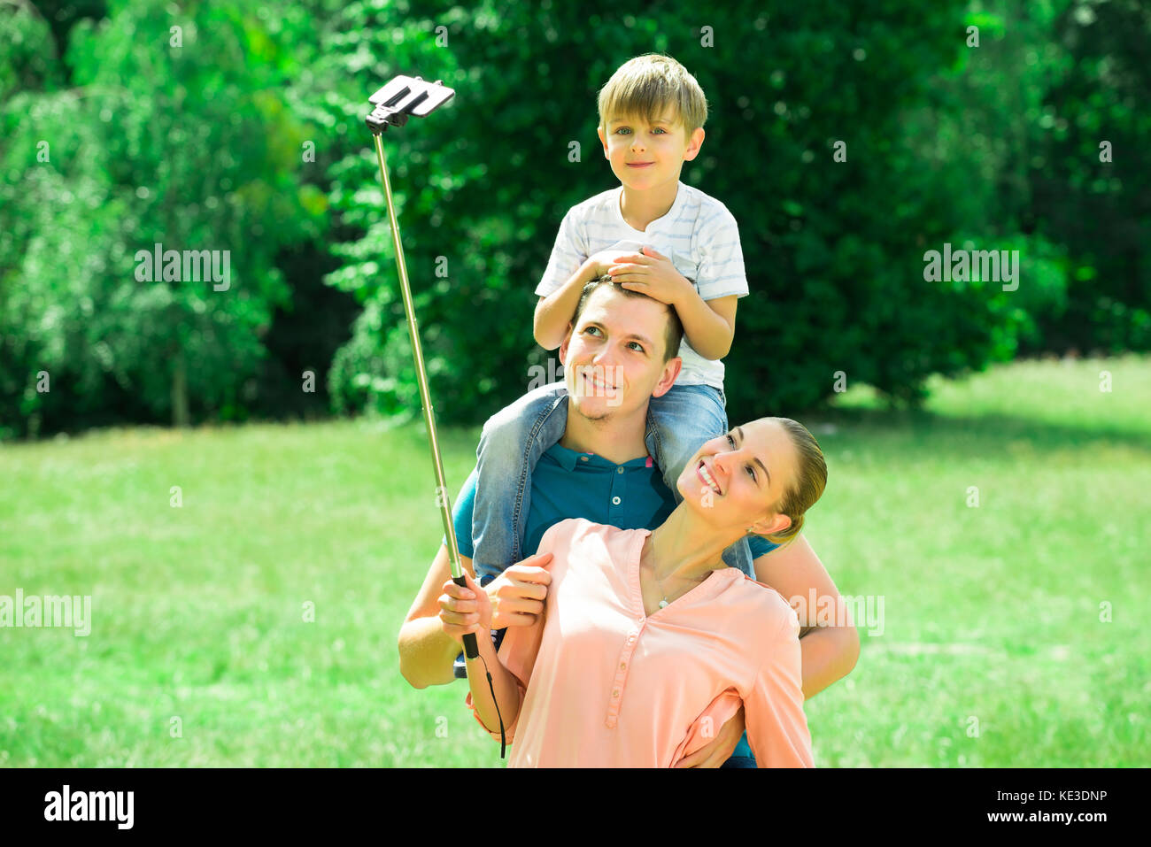 Smiling Young Family Taking Selfie In Park Stock Photo - Alamy