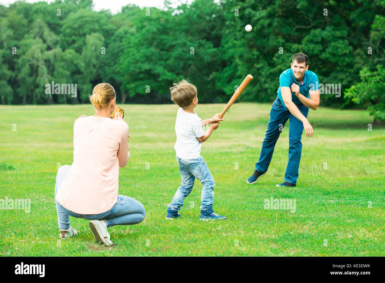 Happy Young Family Playing Baseball At Park Stock Photo