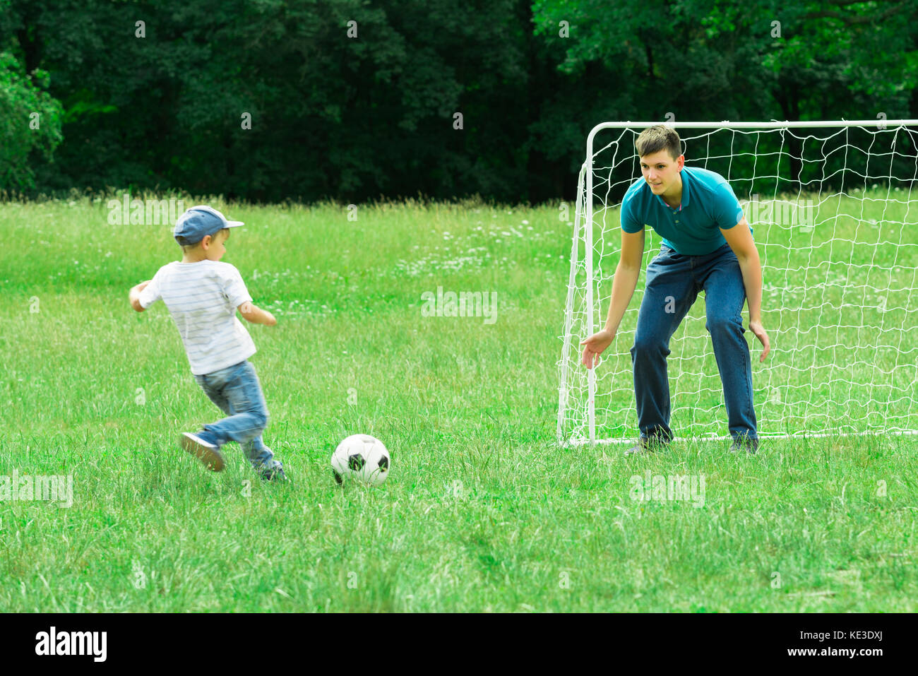 Father And Son Playing Soccer On A Green Grass In The Park Stock Photo ...