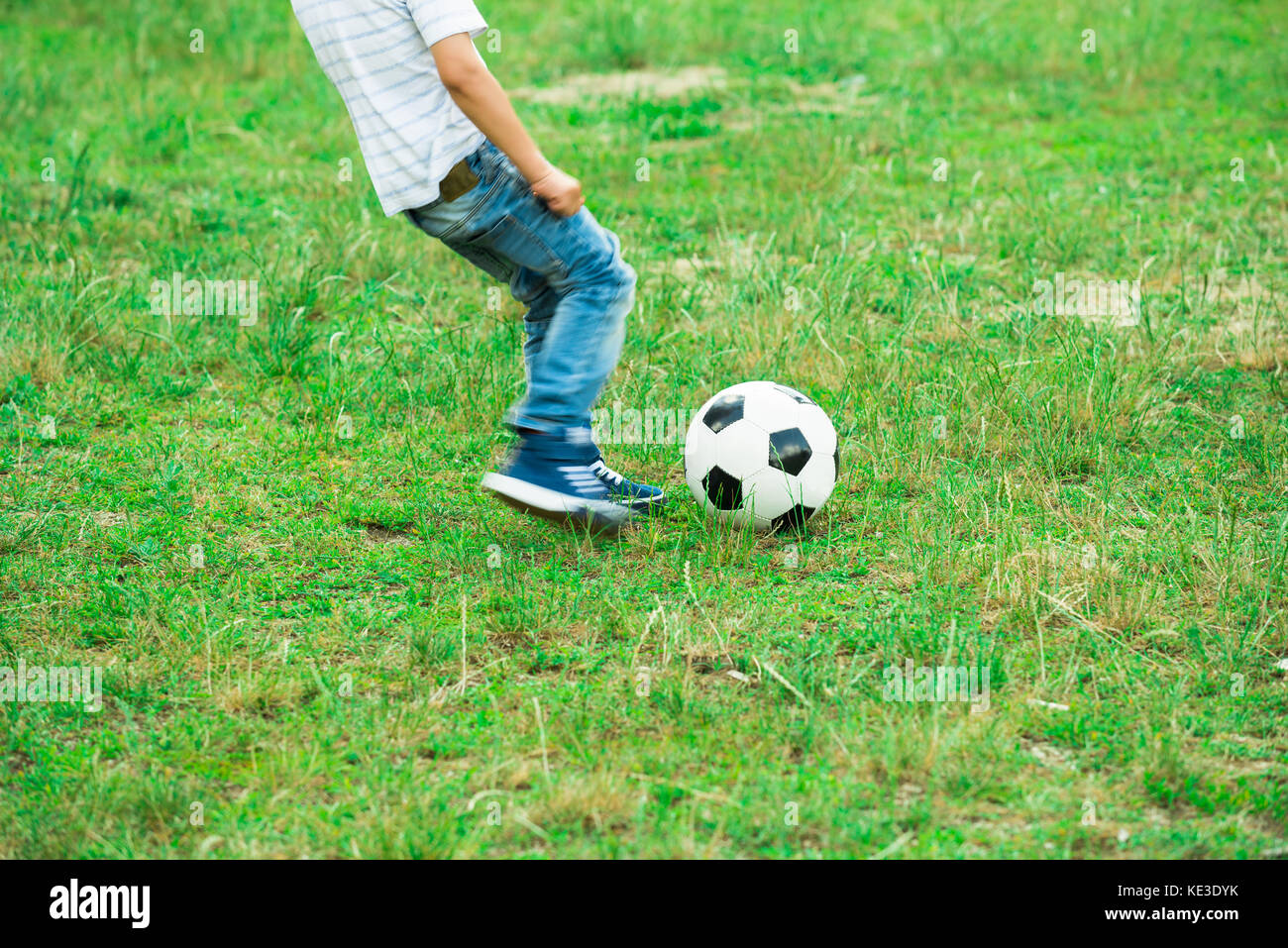Little Boy Playing With Soccer Ball In The Park Stock Photo