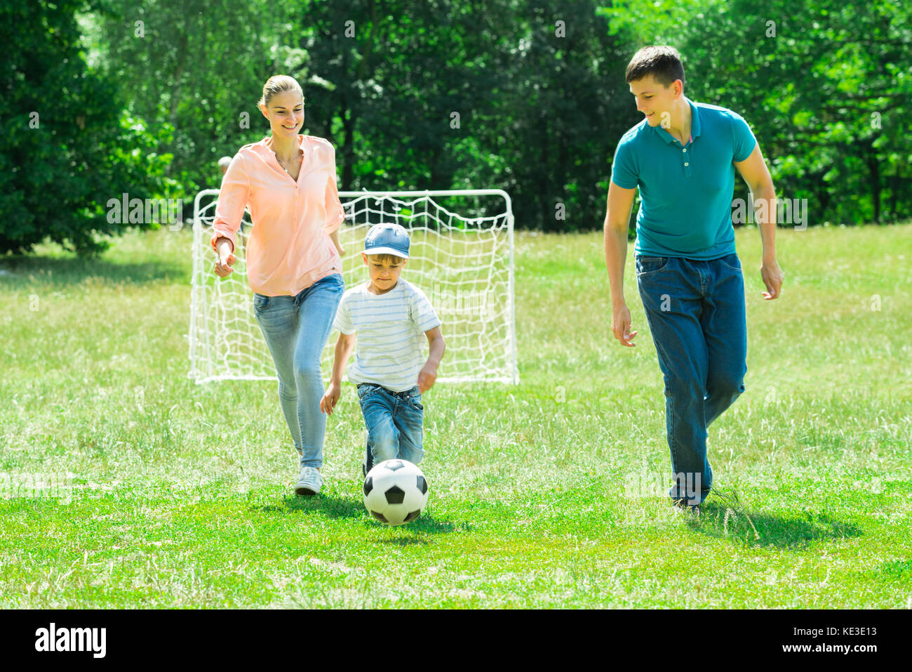 Happy Family Playing With Soccer Ball In The Park Stock Photo - Alamy