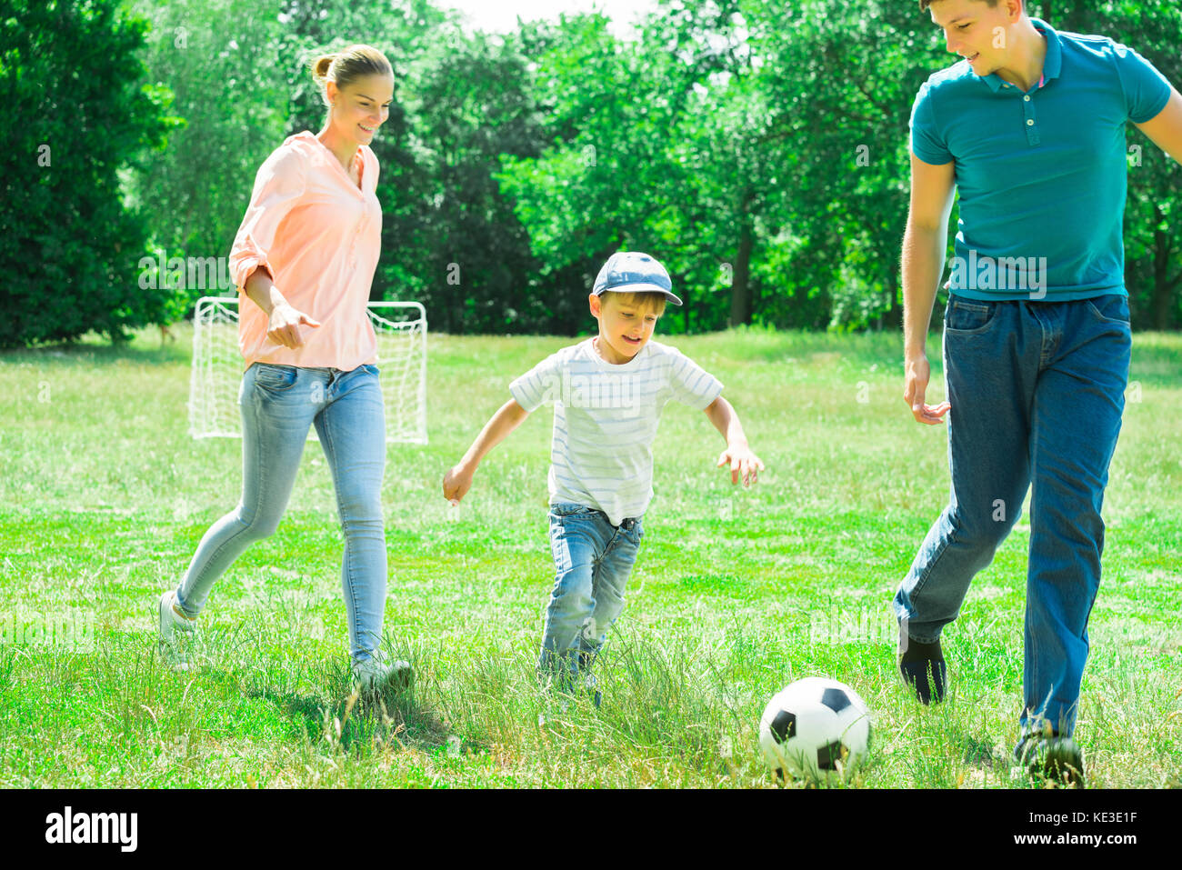 Happy Family Playing With Soccer Ball In The Park Stock Photo - Alamy