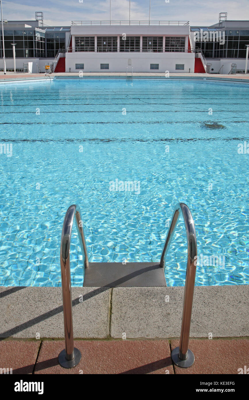Newly refurbished outdoor swimming pool at Uxbridge Lido and sports centre, London, UK. Shows pool ladder with cafe and changing rooms in background Stock Photo