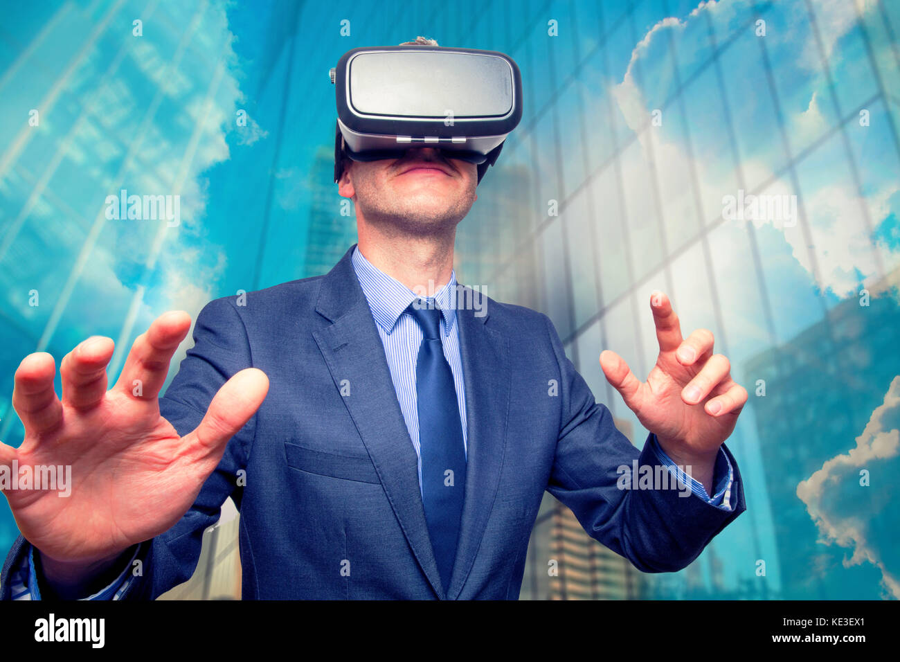 Businessman in a suit wearing Virtual Reality Goggles outside of office ...