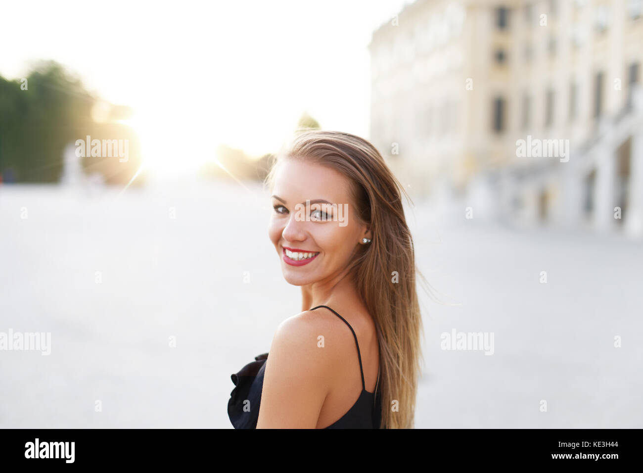 Young brunette woman smiling and looking back at park outdoor Stock Photo