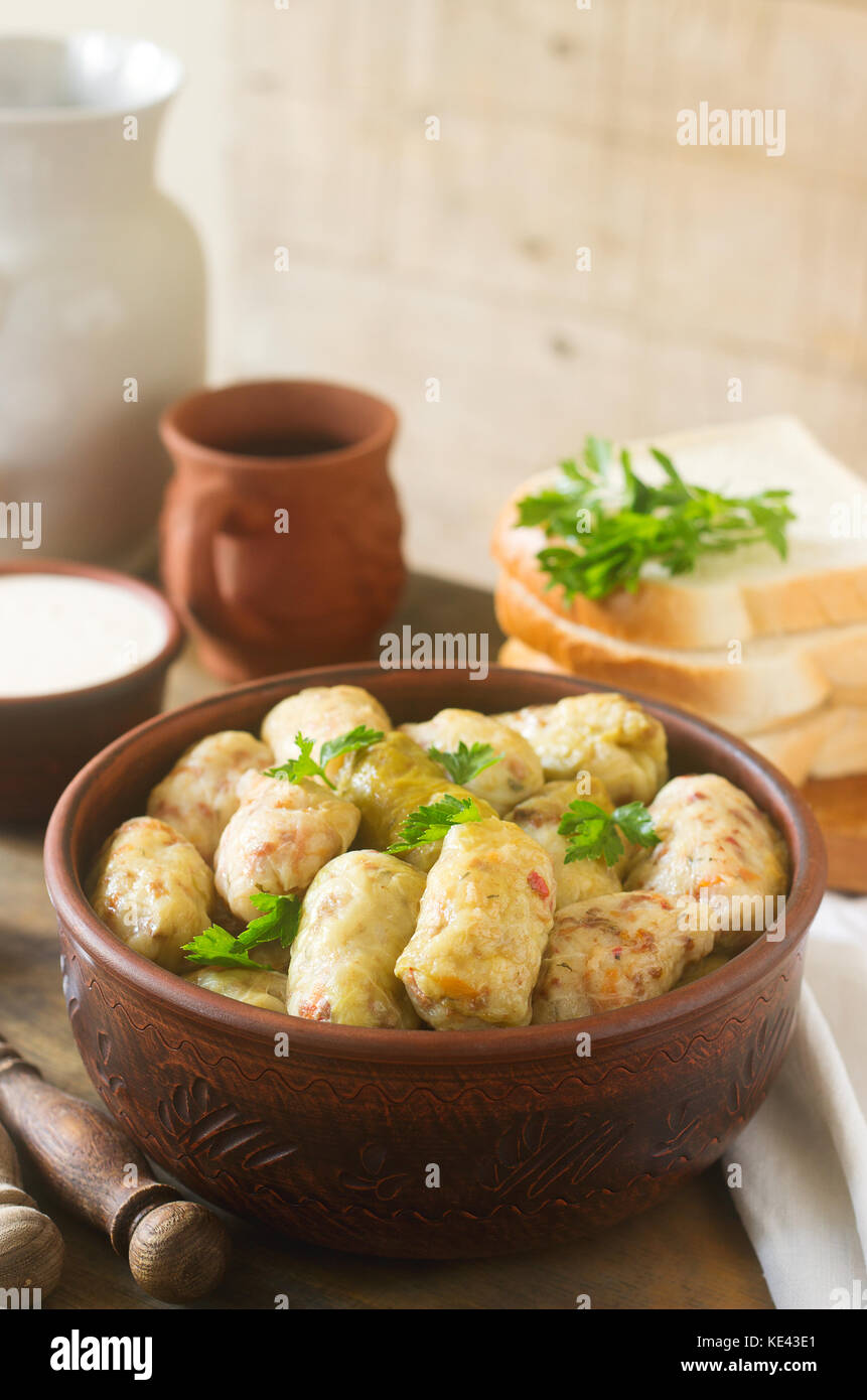 Cabbage rolls served with sour cream, bread and wine. Traditional Moldavian or Romanian Sarmale dish, traditional Russian or Ukrainian golubtsy. Selec Stock Photo