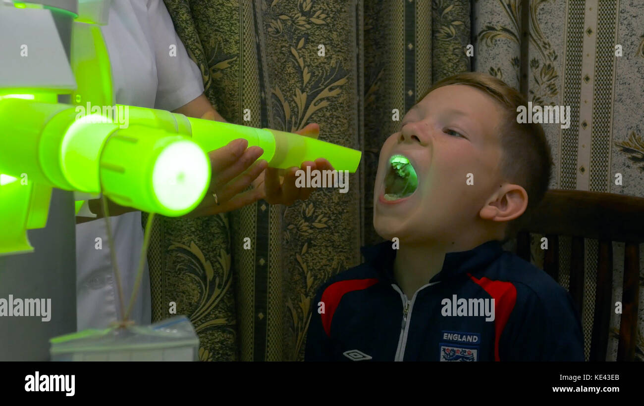 Young boy undergoing treatment in modern clinic. laser inhalation
