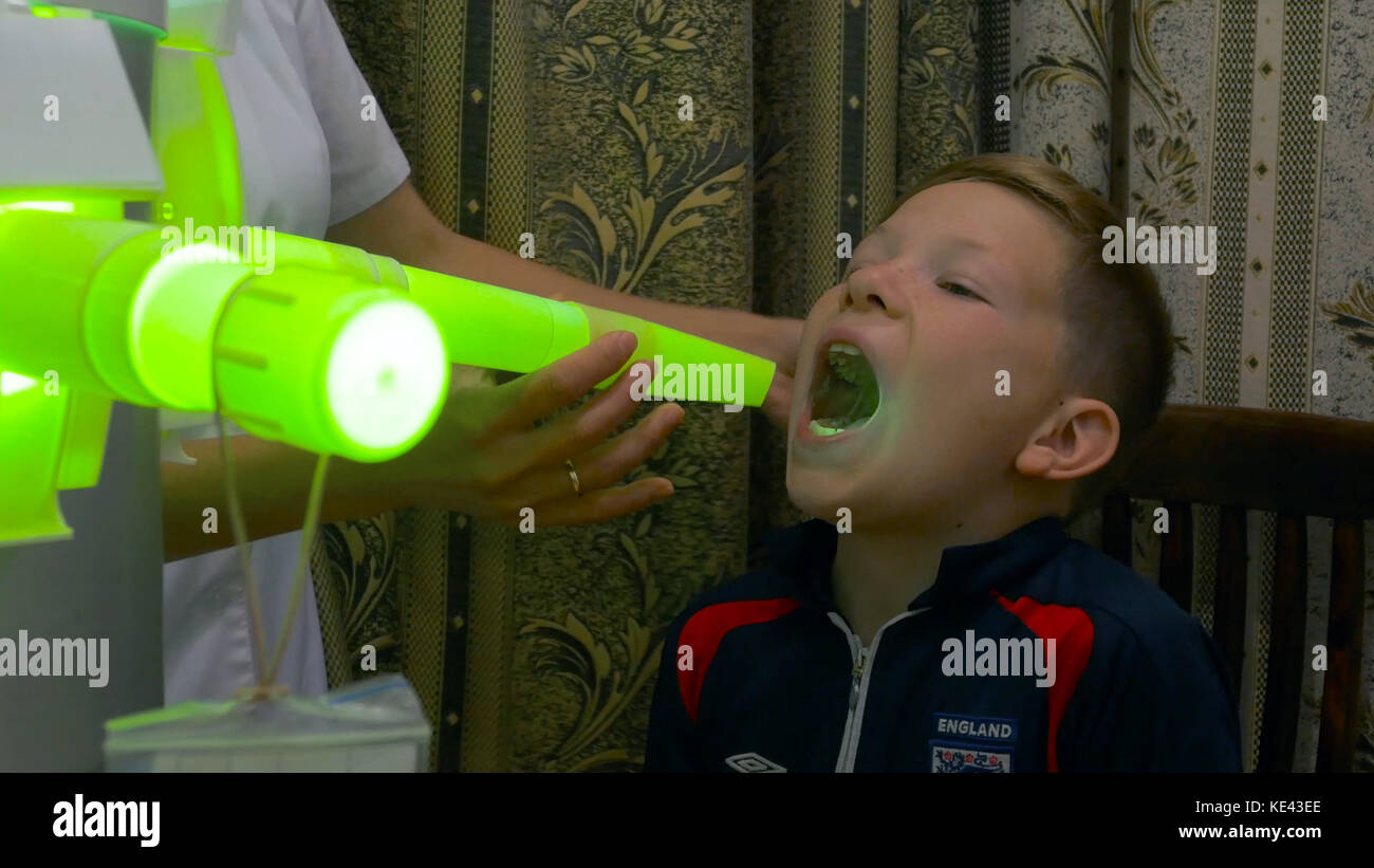 Young boy undergoing treatment in modern clinic. laser inhalation