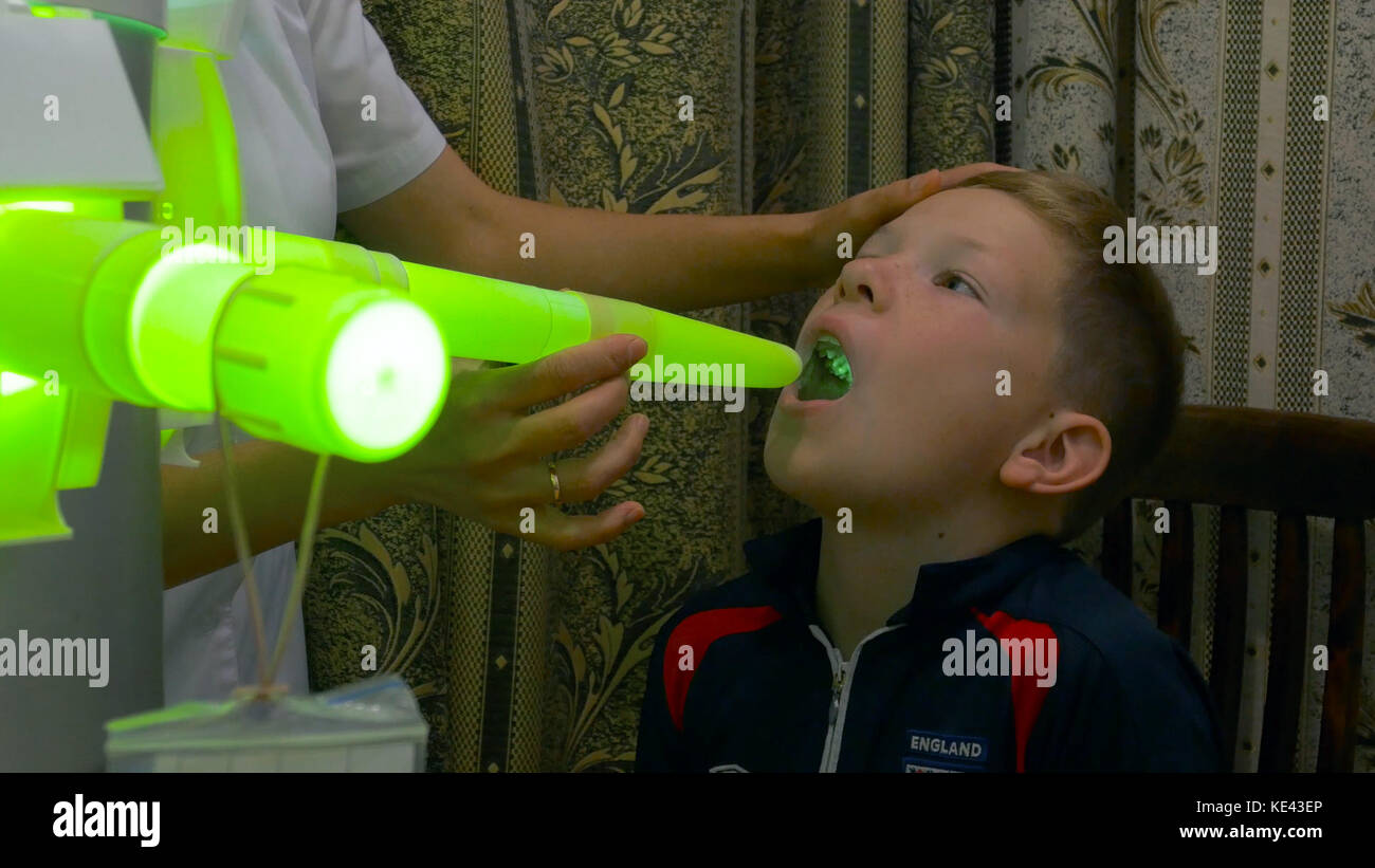 Young boy undergoing treatment in modern clinic. laser inhalation