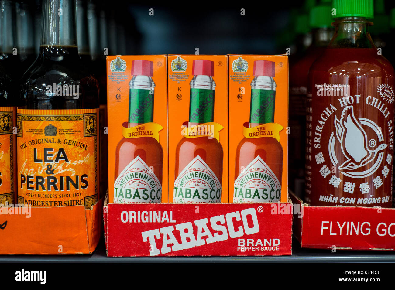 Tobacco and worcester sauce stacked own the shelf in a UK Supermarket Stock Photo