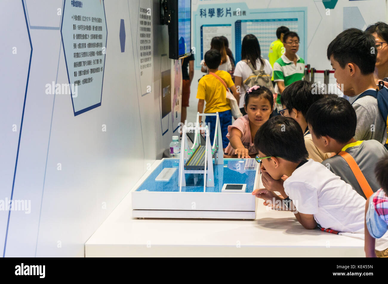 Children learning from interactive science exhibit at a technology fair in Hong Kong SAR Stock Photo