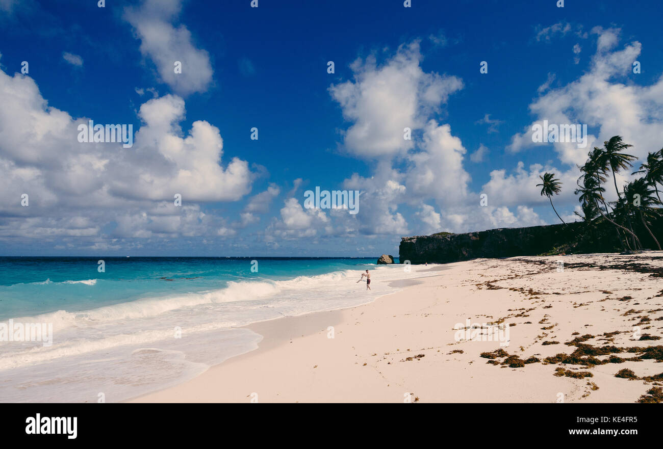 A father swings his child on the beach at Bottom bay. Caribbean island of Barbados. Stock Photo