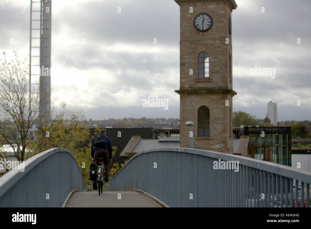 tourist cyclist  on the connecting bridge across the motorway to Clydeside distillery in Glasgow, Scotland Stock Photo