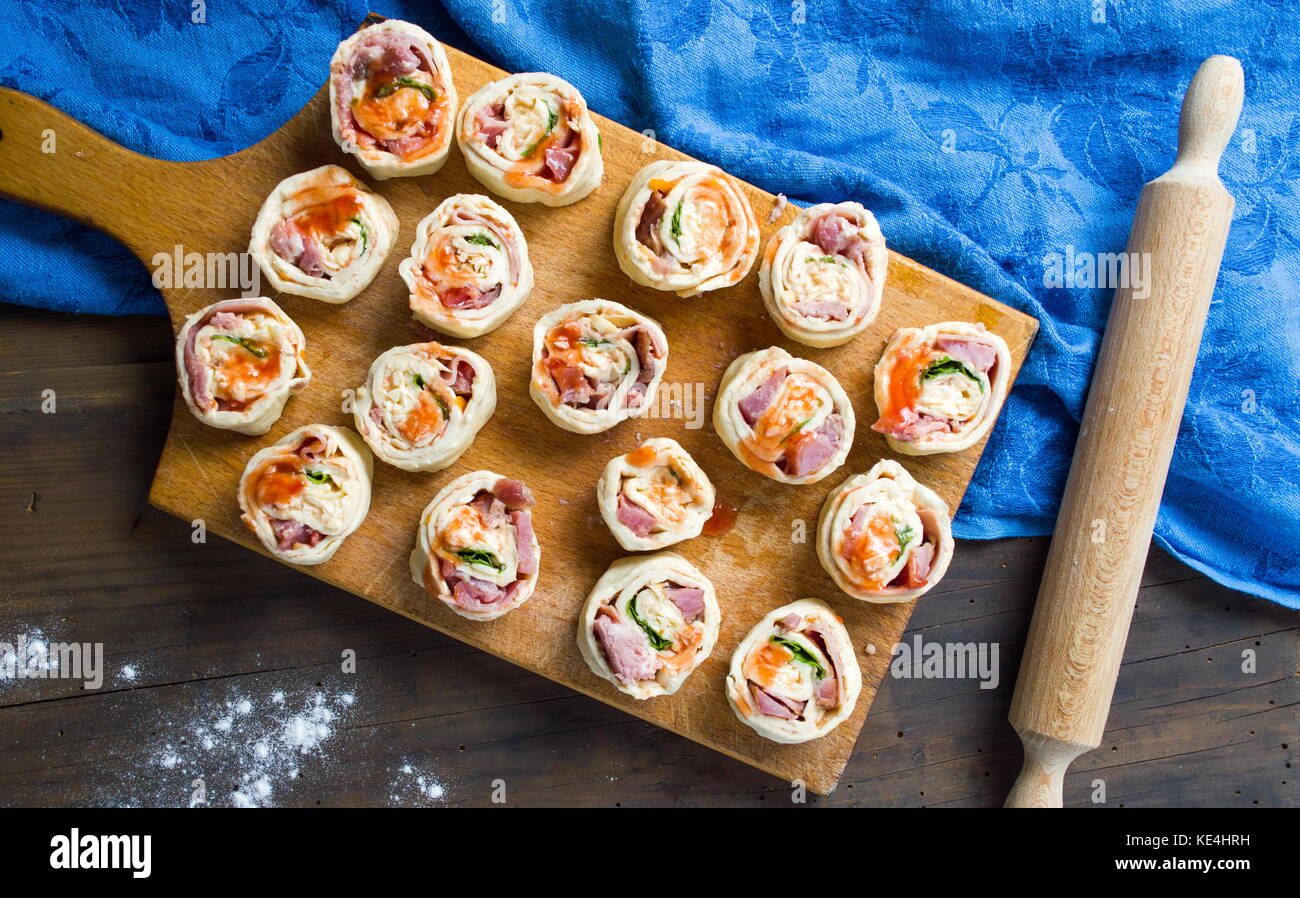 PIzza rolls pastry on a wooden cutting board Stock Photo