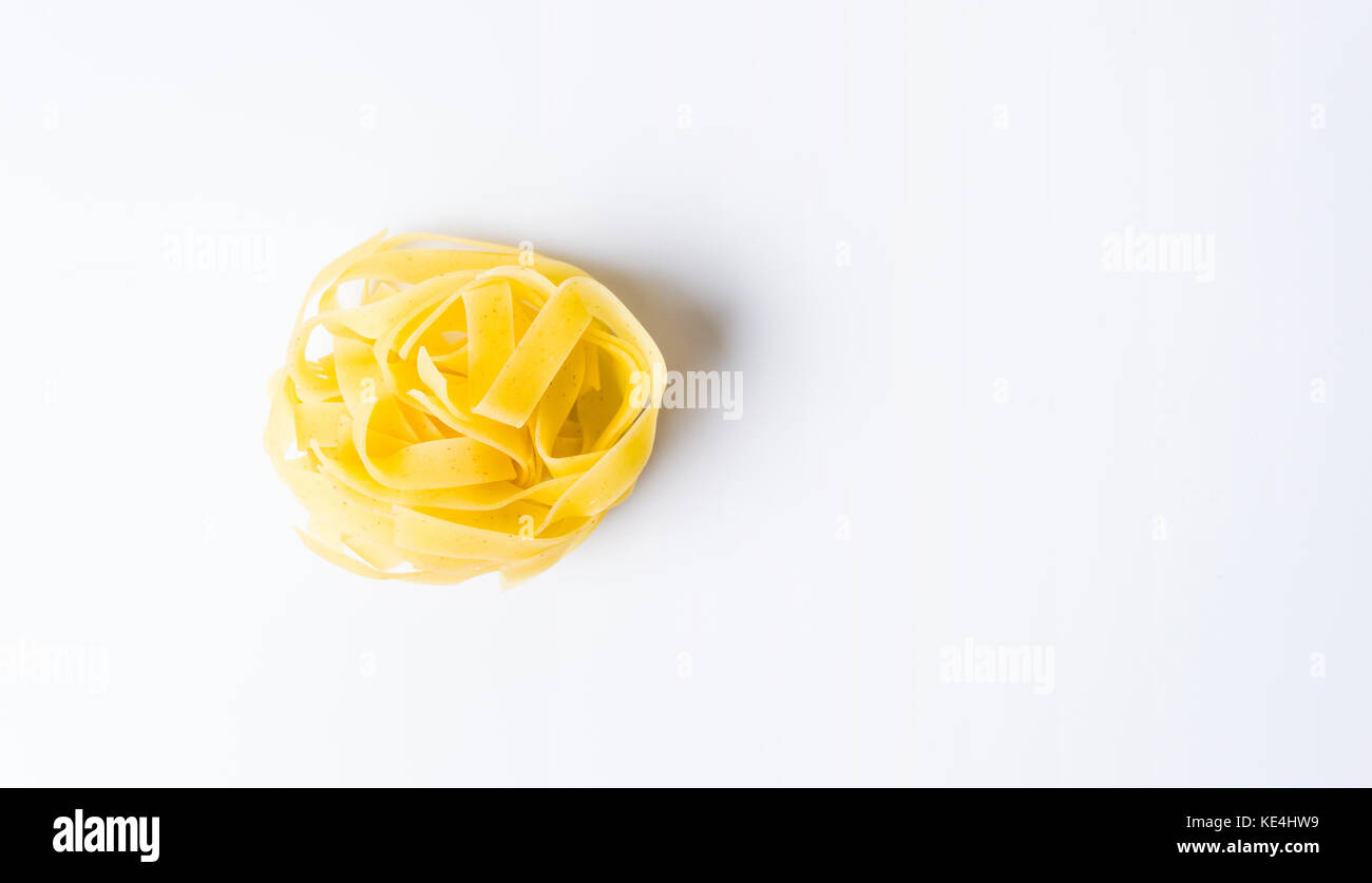 Uncooked round noodle pasta on white background Stock Photo
