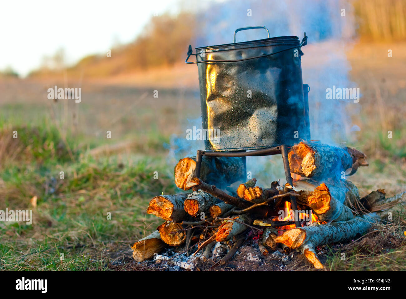 Camping kettle over burning campfire in the morning light Stock Photo ...