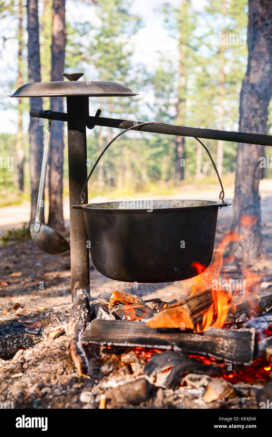 Camping kettle over burning campfire Stock Photo - Alamy