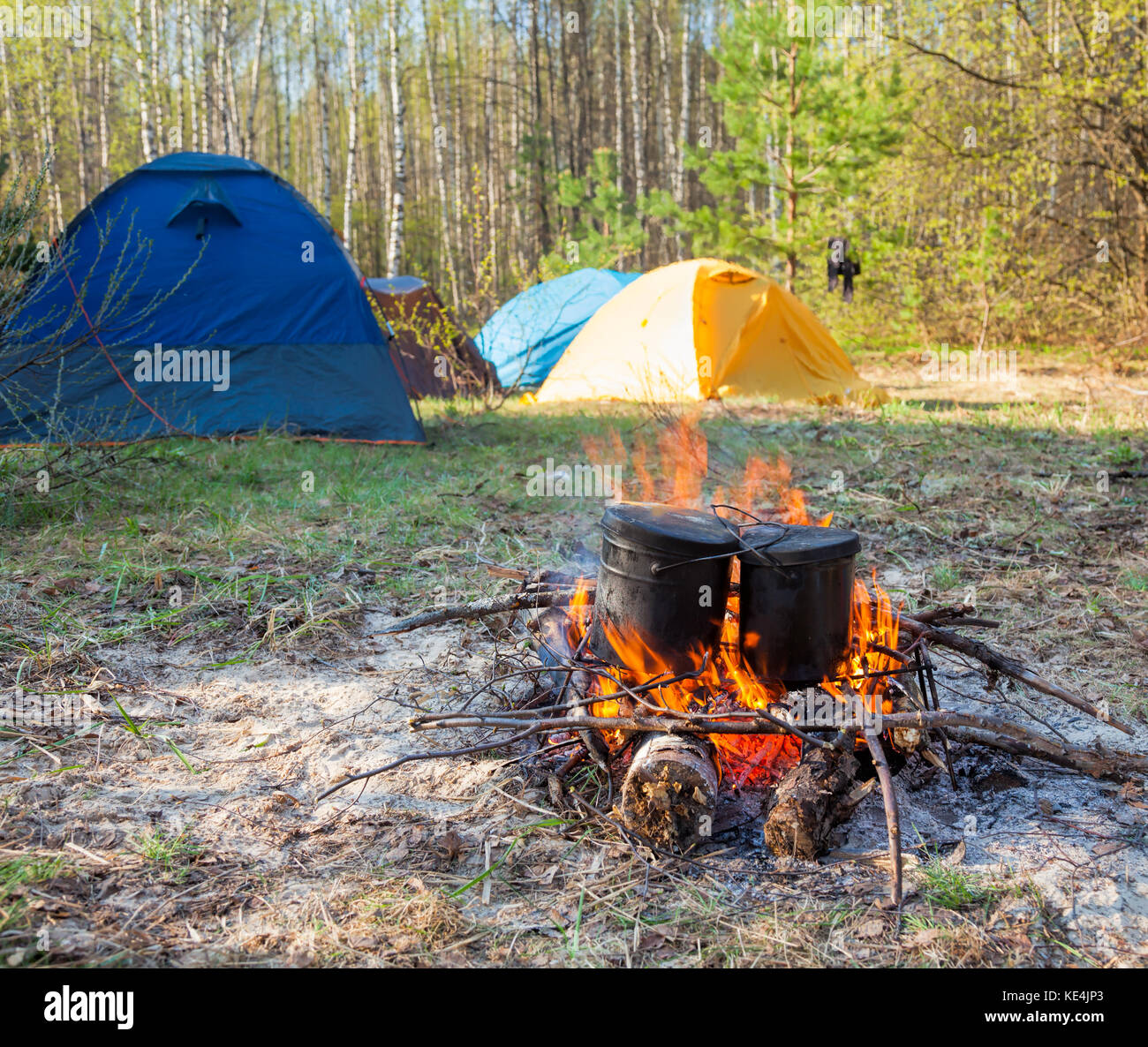 Cauldrons over burning campfire with camping tent in background Stock ...