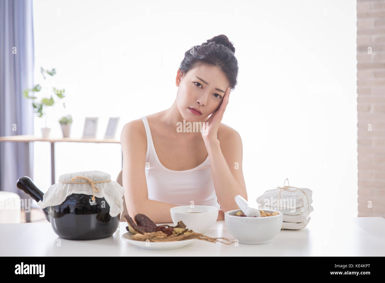 Portrait of young stressful woman with traditional oriental medicine Stock Photo