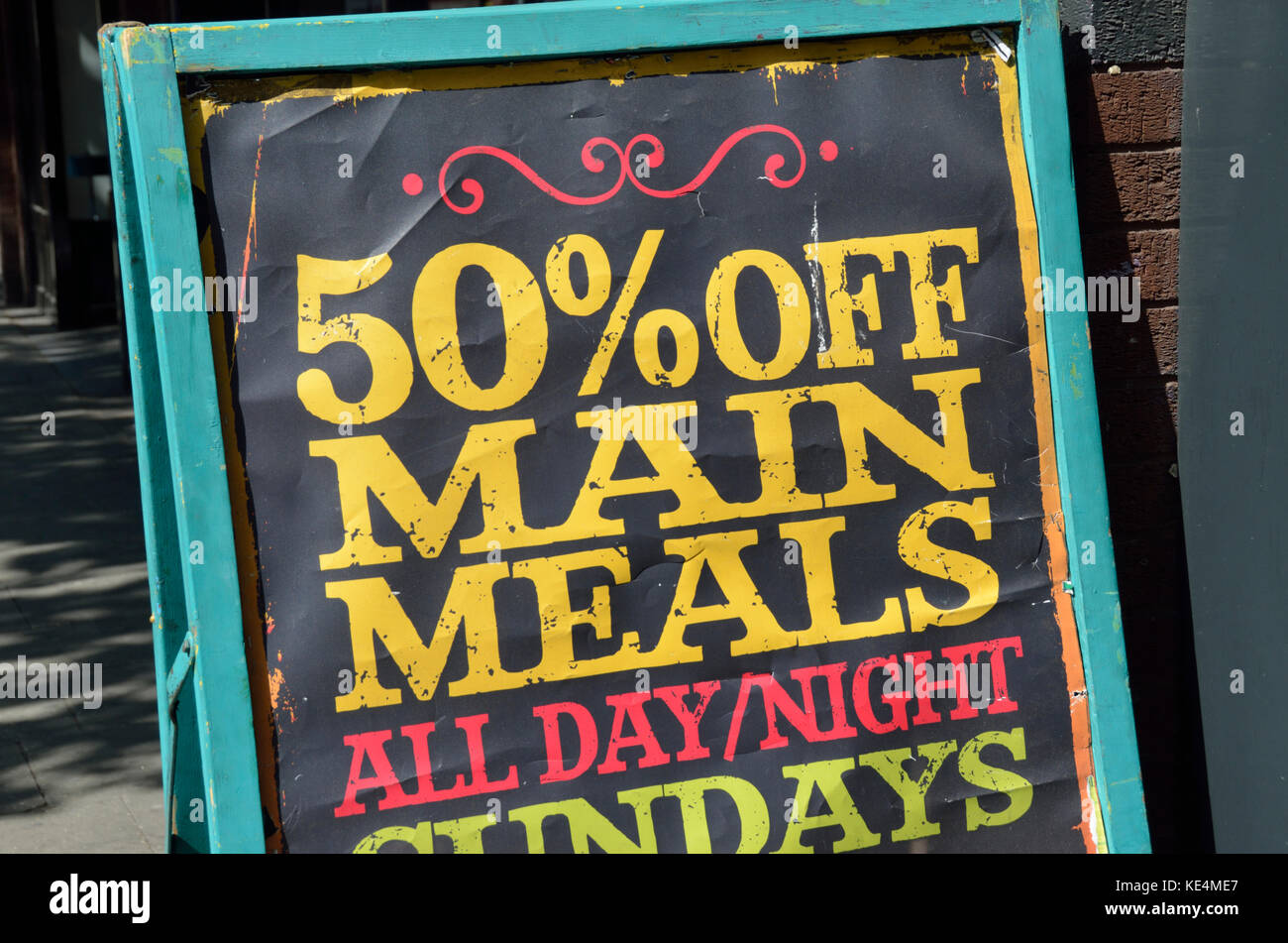 Restaurant board promoting 50 percent off main meals. Stock Photo