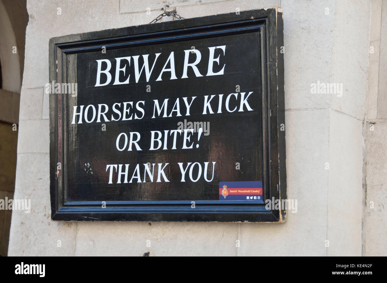 ’Beware horses may kick or bite’ warning sign on a wall. Stock Photo