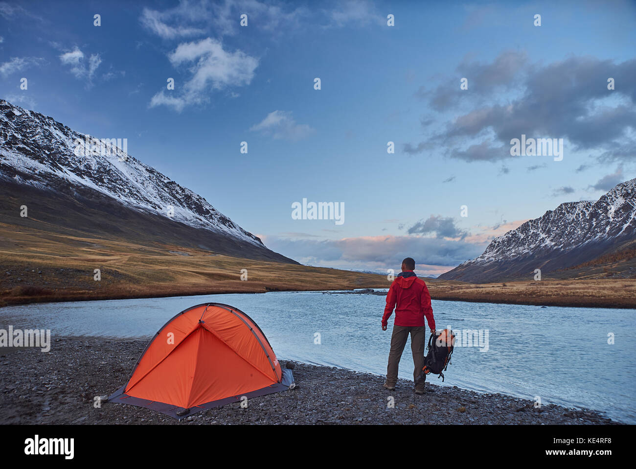 Hiker stand at camping in the mountains during springtime. Stock Photo
