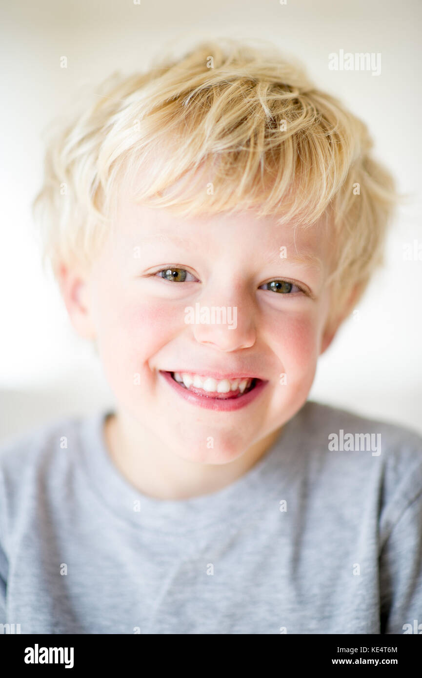 A young blonde haired boy smiling at camera Stock Photo