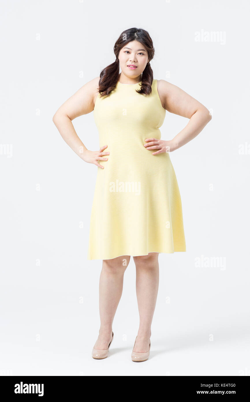 Young smiling fat woman in yellow dress posing Stock Photo - Alamy