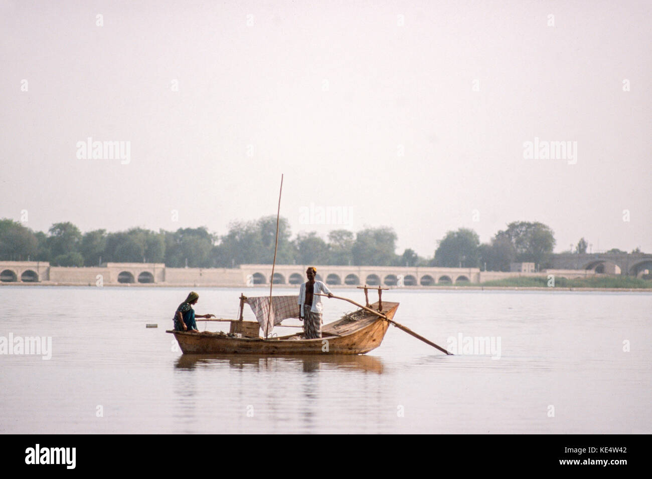 A fisherman and his wife on lake Manchar, Sindh province, Pakistan beside the British-built barrage at Sukkur, that created the lake in the 1930's. Stock Photo
