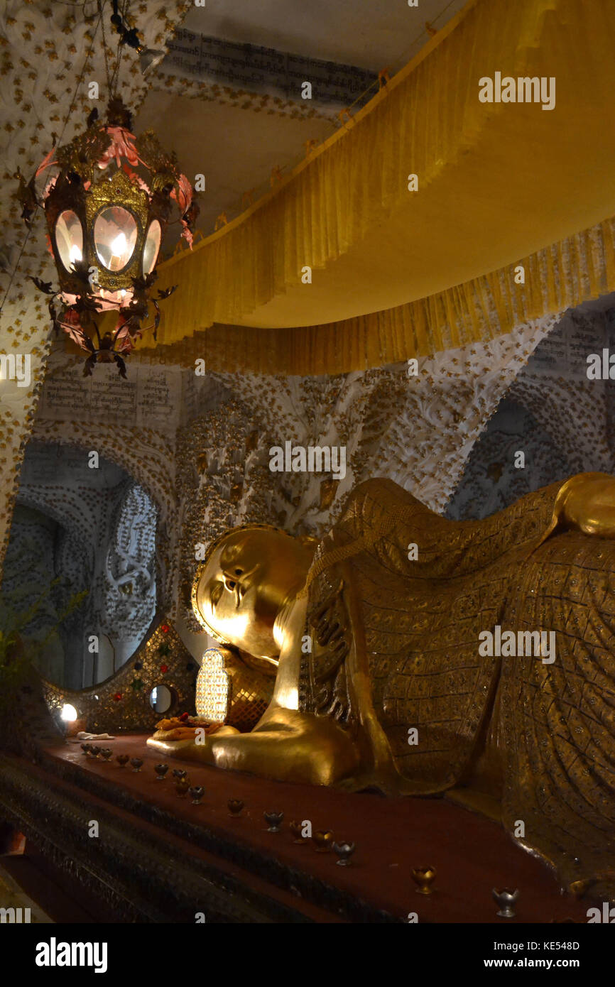 A temple housing one golden reclining Buddha statue. Location is in Mandalay, Myanmar. Pic was taken in August 2015 Stock Photo
