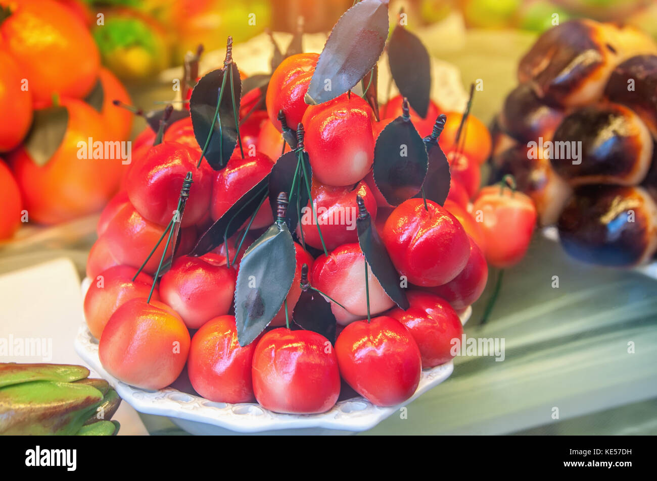 Cakes with marzipan in the form of cherries . Typical Sicilian. The horizontal frame. Stock Photo