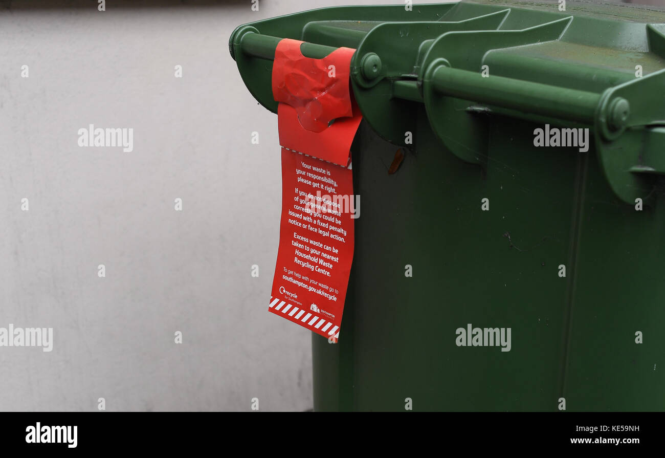 Warnings attached to Southampton city council waste bins on what rubbish can be put in bins and advising legal action if abused. Stock Photo