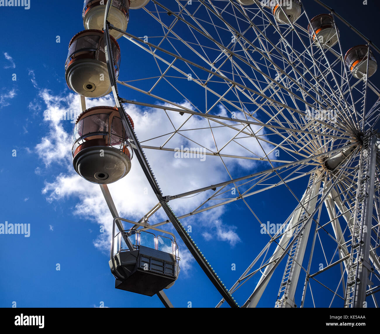 Temporary mobile ferris wheel against a blue sky with a single white cloud located in Southampton England. Stock Photo
