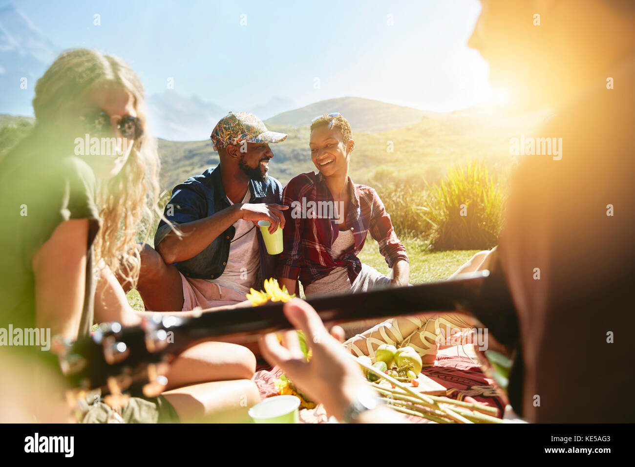 Young friends enjoying picnic in sunny summer park Stock Photo