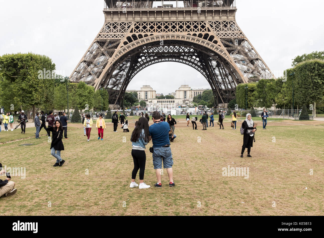 Tourists take photos of themselves with the Eiffel Tower on the camps de mars in Paris, France Stock Photo