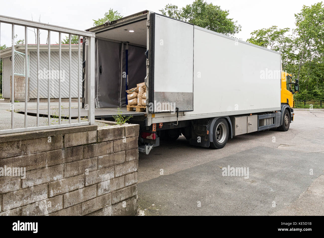 Parcel delivery truck loading or offloading at loading bay  Model Release: No.  Property Release: No. Stock Photo
